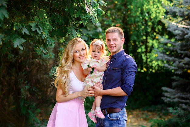 Mama, Papa und kleine Tochter gehen in den Park