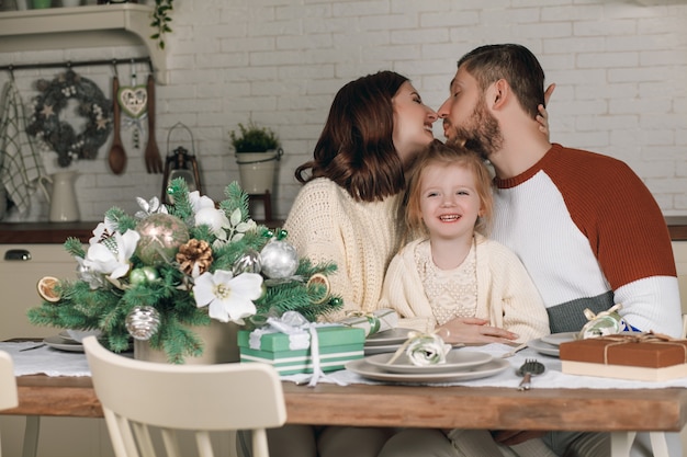 Mama, Papa und schöne Tochter sitzen am Küchentisch