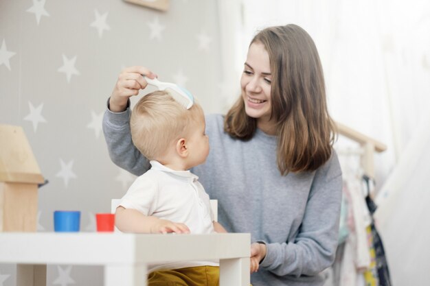 mamá peinando el pelo de un bebé