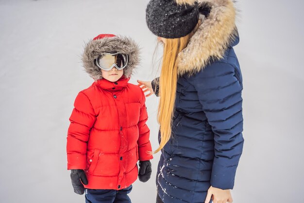 Mamá se pone gafas de esquí para su hijo