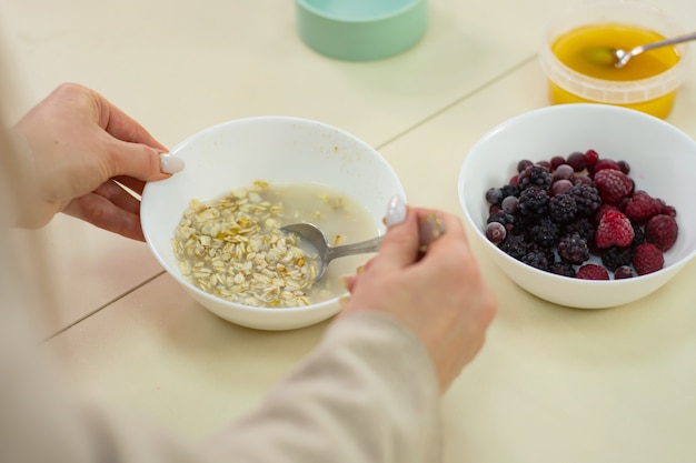 Mamá prepara avena con miel en la cocina