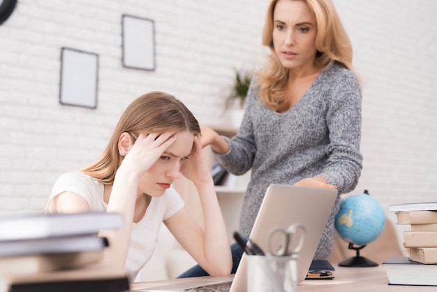 Mamá regaña a su hija por un mal trabajo en la computadora portátil.