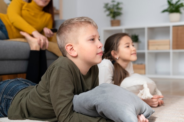 Mama sieht mit ihren Kindern fern