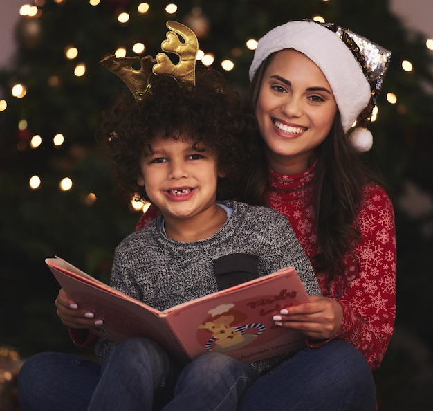 Mamá siempre elige las mejores historias. Foto de una joven madre y su hijo leyendo un libro durante la Navidad en casa.