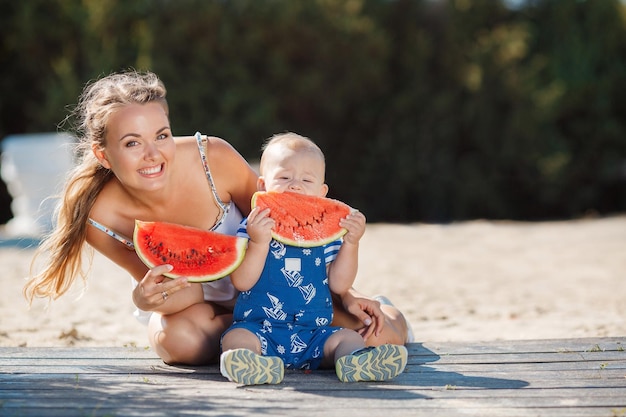 mamá sonriente con un lindo bebé al aire libre