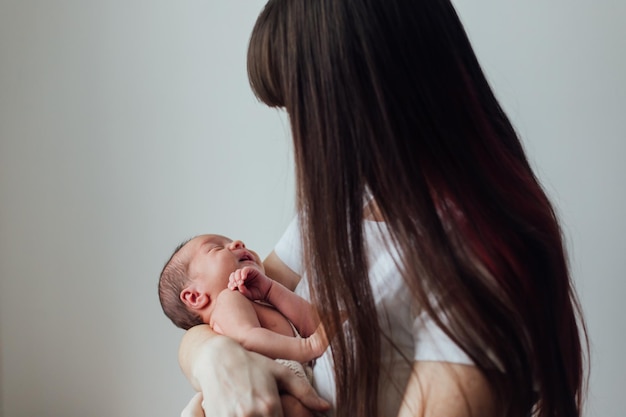 Mamá sostiene al bebé en sus brazos estilo de vida El amor de la madre por su hijo Un bebé recién nacido