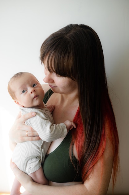 Mamá sostiene al bebé en sus brazos estilo de vida El amor de la madre por su hijo Un bebé recién nacido