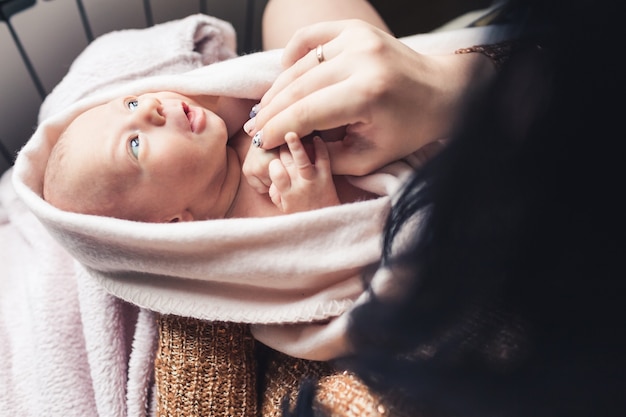 Mamá sostiene a su bebé recién nacido en sus brazos. Concepto suave de maternidad.