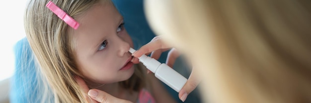 Mama sprüht Babys Nase mit Spray ein