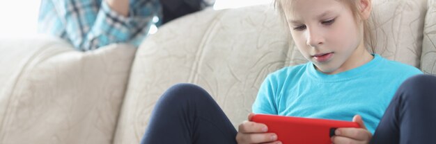 Mama steuert ihre Tochter mit dem Telefon durch ein Fernglas