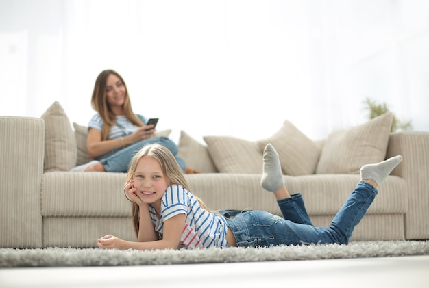 Mamá y su hija descansan en la nueva sala de estarfoto con espacio para copiar