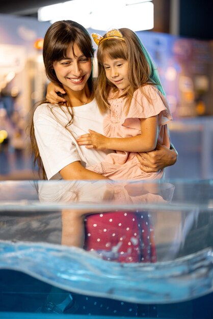 Mamá con su hija pequeña visitan un museo de ciencias