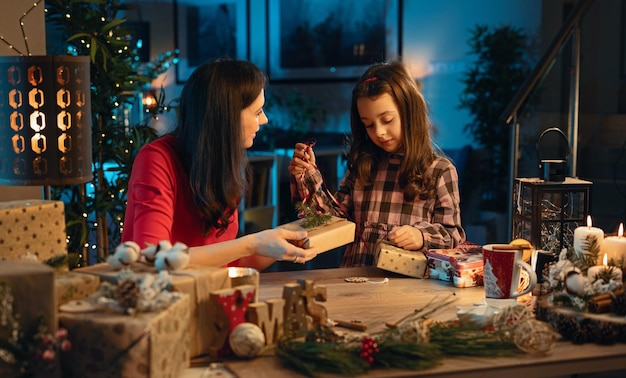 Mamá y su hija preparando regalos para Navidad