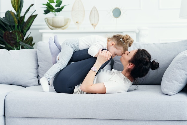 Mamá y su hija recostada en el sofá de la sala de estar