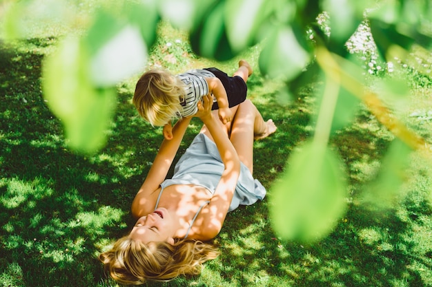 Foto mamá y su hijo pintan sobre la naturaleza.