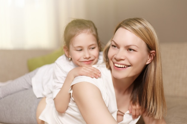 Mamá y su linda hija jugando, sonriendo y abrazándose