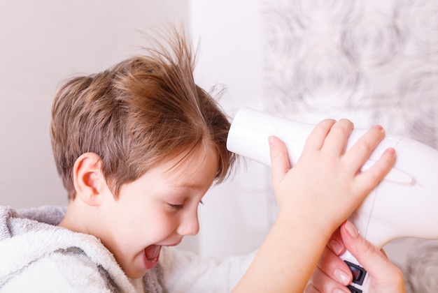 Foto mama trocknet babyhaar mit einem haar trocknet