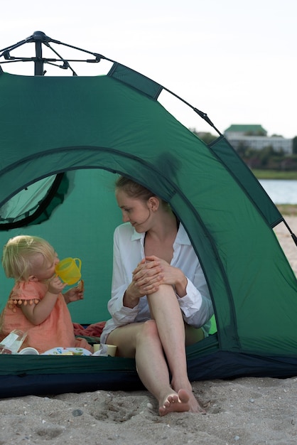 Mama und Baby spielen im Touristenzelt auf dem Campingplatz