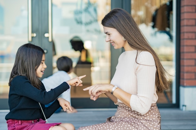 Mama und ihre Kinder spielen von Hand mit einem Lächeln im Freien