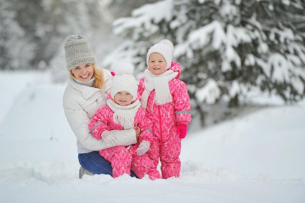 Mama und Kinder bei einem Spaziergang im Winter im Wald.