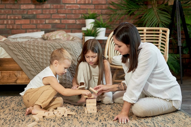 Mama und Kinder spielen Squirl Tower.