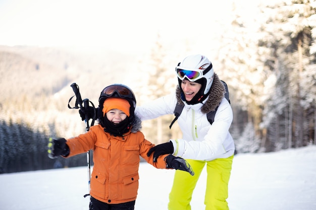 Foto mama und sohn in skiausrüstung auf der skipiste