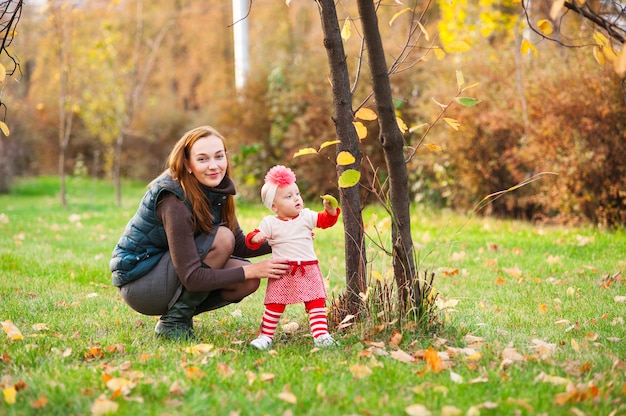 Mama und Tochter spielen im Herbstpark.