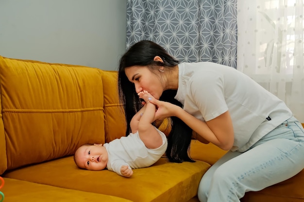 Mamãe beija as pernas de um bebê recém-nascido o conceito de um beijo amor maternal