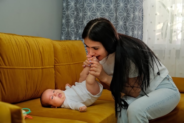 Mamãe beija as pernas de um bebê recém-nascido o conceito de um beijo amor maternal