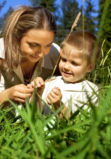 Mamãe e filho caminhando pela grama