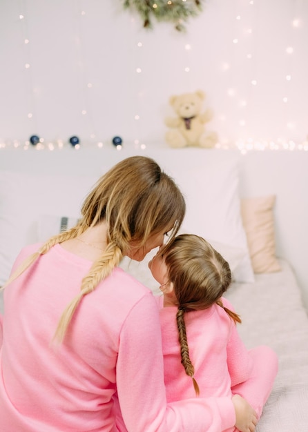 Mamãe filha penteado com tranças pijama rosa brincar