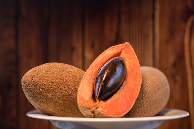 Foto mamey frutas fatiadas close-up fundo de madeira