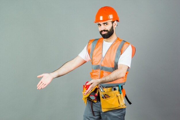 Man Builder con barba de pie en el espacio de copia de fondo gris