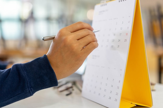 Man Hand Stift zum Zeigen Zeitplan (Zeitplan) oder markieren Sie wichtigen Tag im Kalender