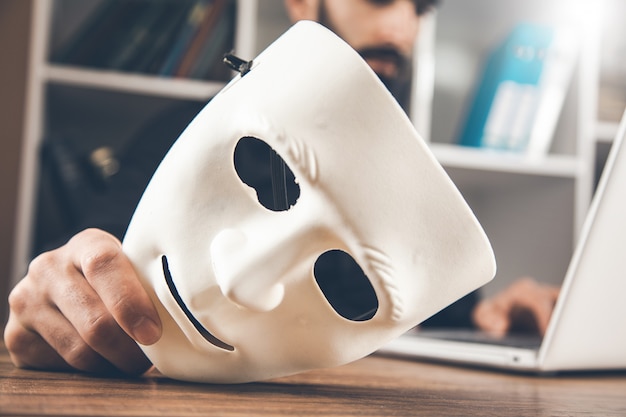 Foto man hand weiße maske mit computer auf schreibtisch