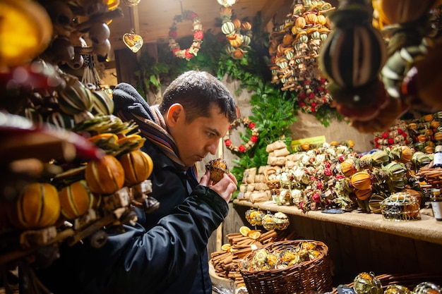 Man kauft Geschenk am Weihnachtsmarkt Reisen und Urlaub im Winter