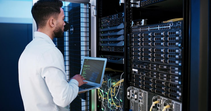 Foto man laptop and typing for programming in server room hardware and inspection for it solution at company person cybersecurity and assessment with computer coding and update software for system