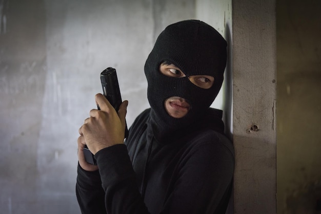 Man Räuber Dieb trägt eine Maske mit Waffe, die bewaffnete wartende Verbrecher versteckt