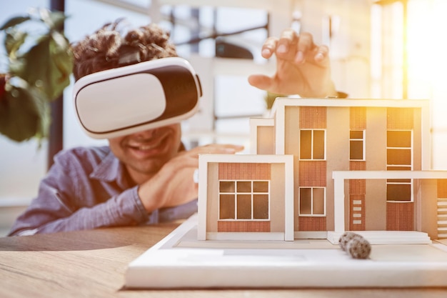 man sits in the office of a realtor and looks at the layout of the apartment in virtual reality glasses