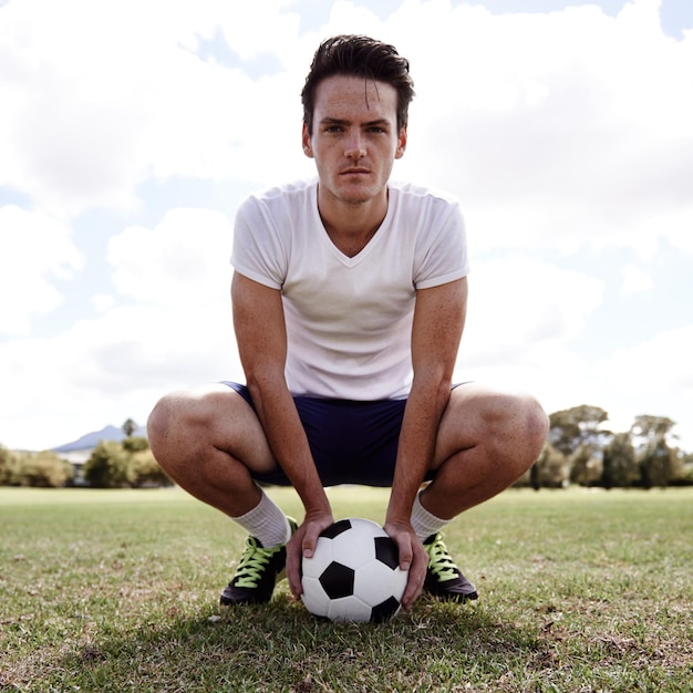 Foto man soccer ball and portrait on ground for sports with pride confidence and ready for challenge on field person athlete and football player on grass for exercise workout and training for game