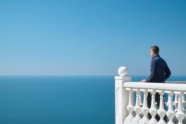 Man steht auf dem Balkon und schaut aufs Meer