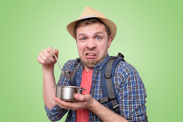 Man Tourist im Sommerhut schmeckt eine seltsame Mahlzeit