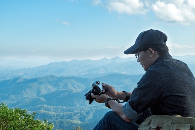 Man Traveler com câmera fotográfica e mochila caminhadas ao ar livre Travel Lifestyle and Adventure concept.