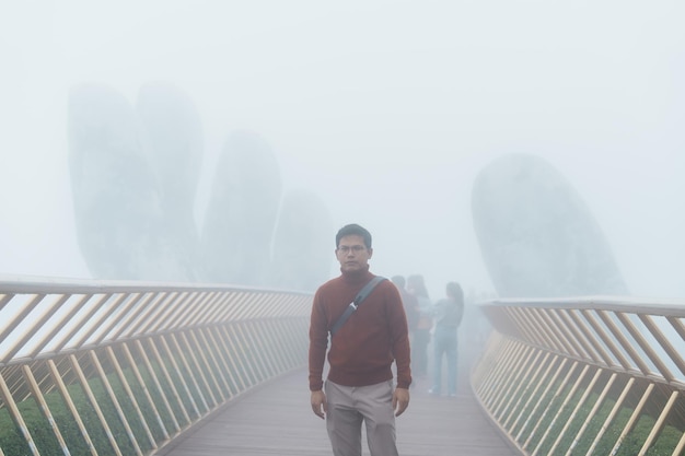 Man Traveler Sightseeing Goldene Brücke an der Spitze des Wahrzeichens von Ba Na Hills und beliebtes Reisekonzept für Vietnam und Südostasien