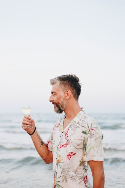 Man trinkt ein Glas Wein am Strand