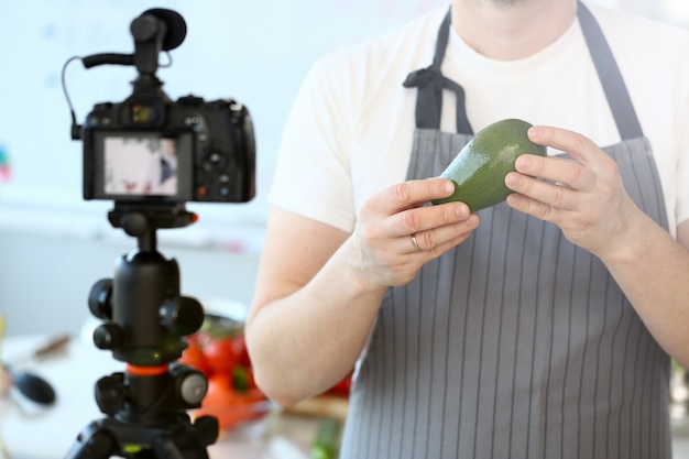 Man Vlogger zeigt reife tropische Avocado-Frucht