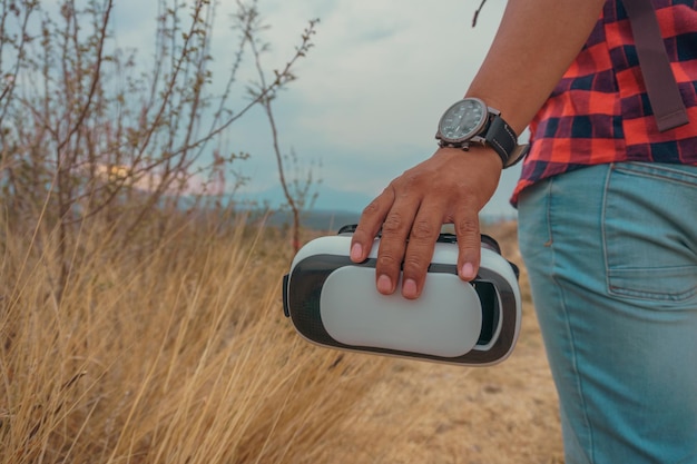 Man39s Hand hält eine VR-Brille auf dem Berg