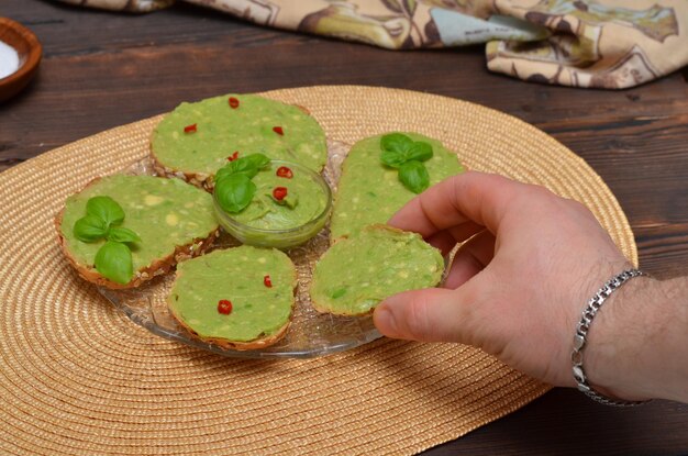 Man39s Hand nimmt Sandwiches mit Guacamole