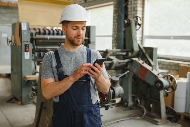 Management-Team-Ingenieur oder Vorarbeiter Stehend, der Jobinformationen über das industrielle Produktionsmanagement innerhalb der Fabrik per Telefon überprüft Teamwork-Konzept