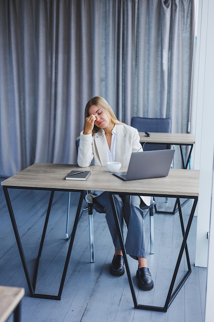 Manager konzentrierte sich auf eine Frau in Freizeitkleidung und Brille, die auf einem Netbook tippte, während sie an einem neuen Projekt arbeitete, das am Tisch in einem modernen Arbeitsbereich saß